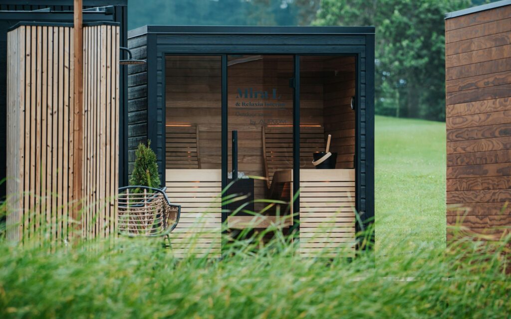 Eckige Gartensauna mit Glasfront auf einer Wiese